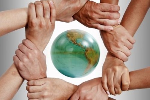 Kädet maapallon ympärillä.