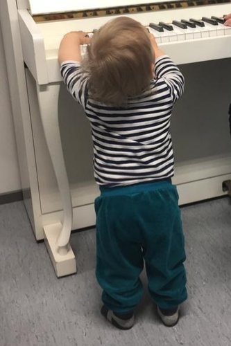 Pieni lapsi soittaa pianoa